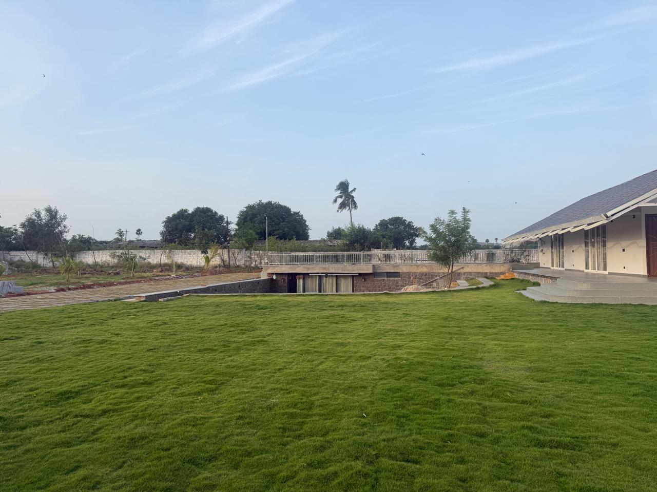 Open lawn with the stone level and boundary wall in the distance