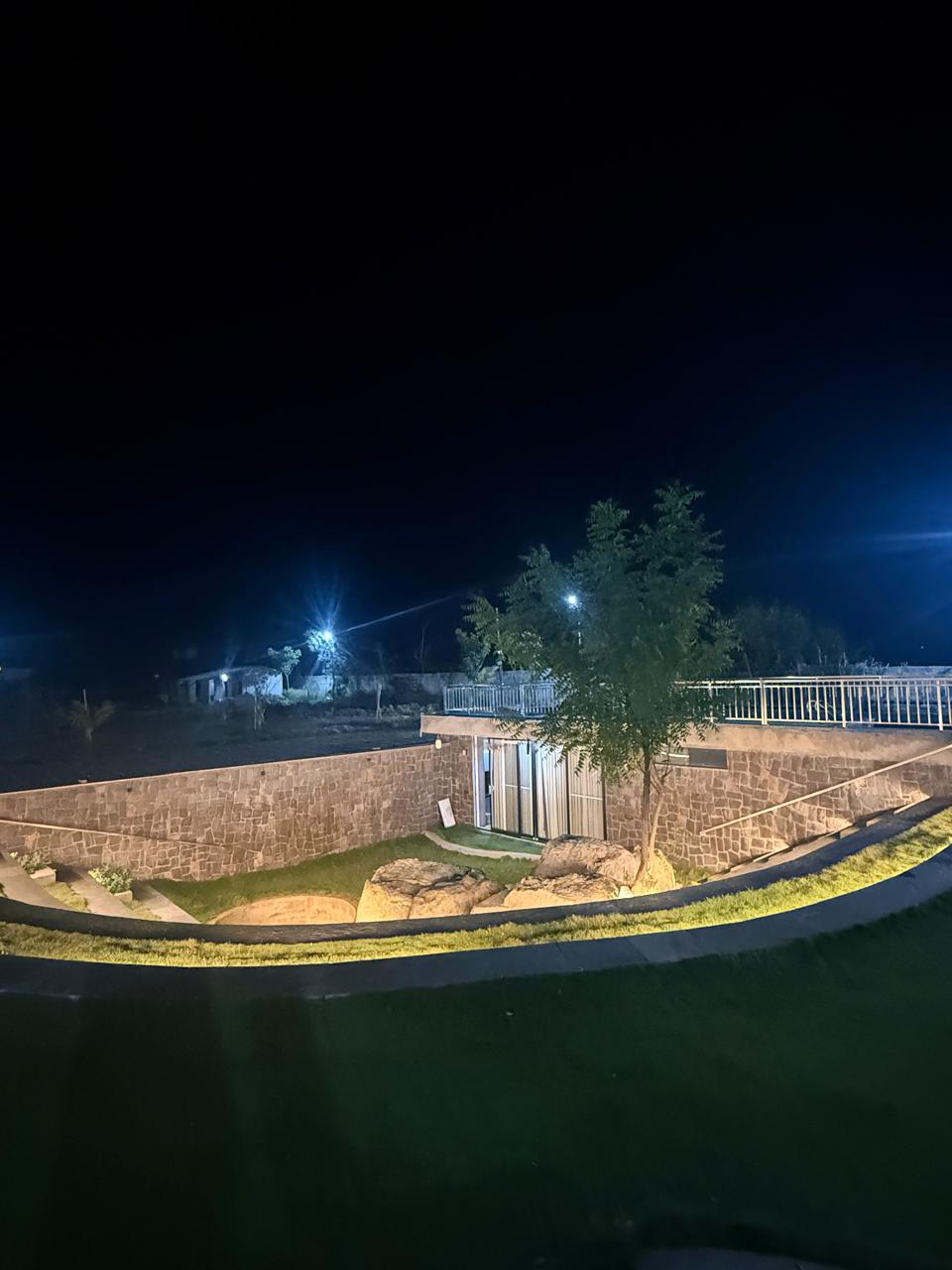 Underground courtyard at night, framed by the boundary wall